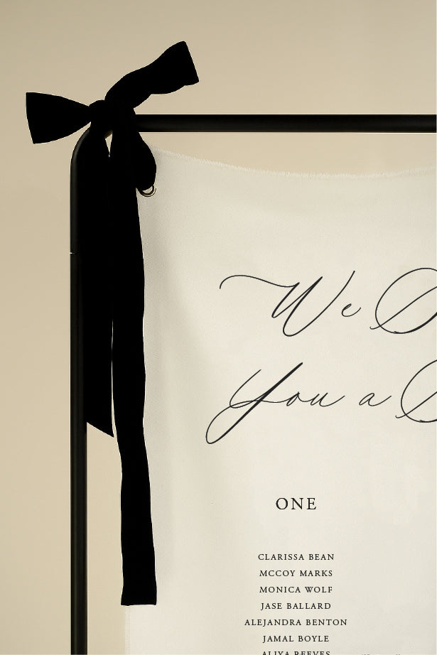 Book cover with a black ribbon and 'We Do You A' text on a beige background