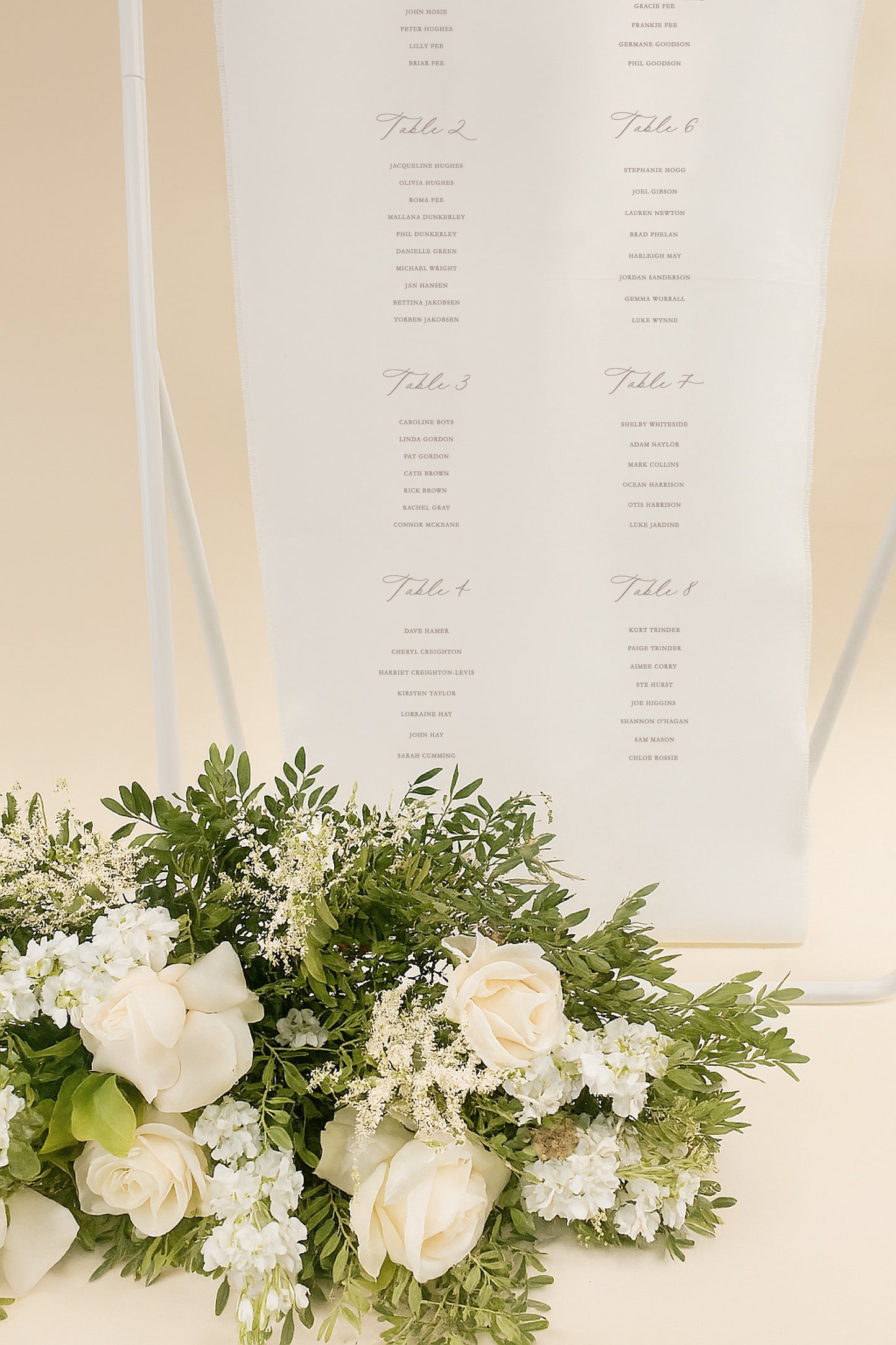 Floral arrangement with a seating chart in the background