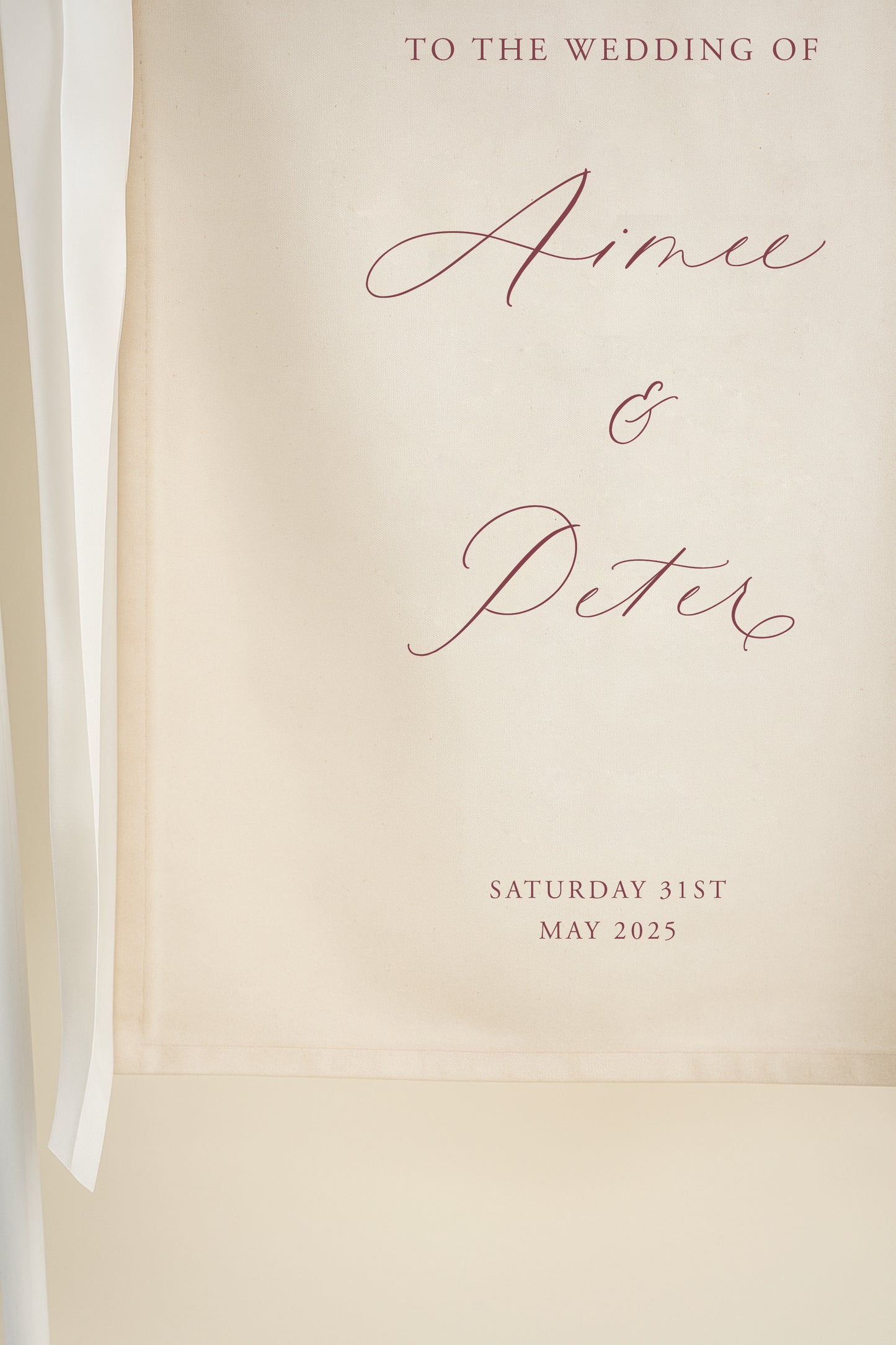Wedding invitation card with 'To the wedding of Aimée & Peter' text on a beige background.