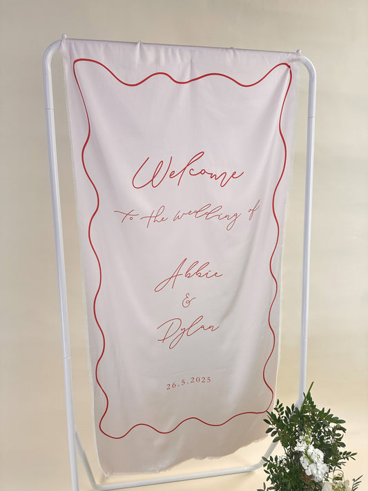 Wedding welcome sign with red text on a white background