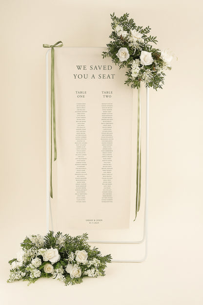 Wedding seating chart with floral decorations on a beige background