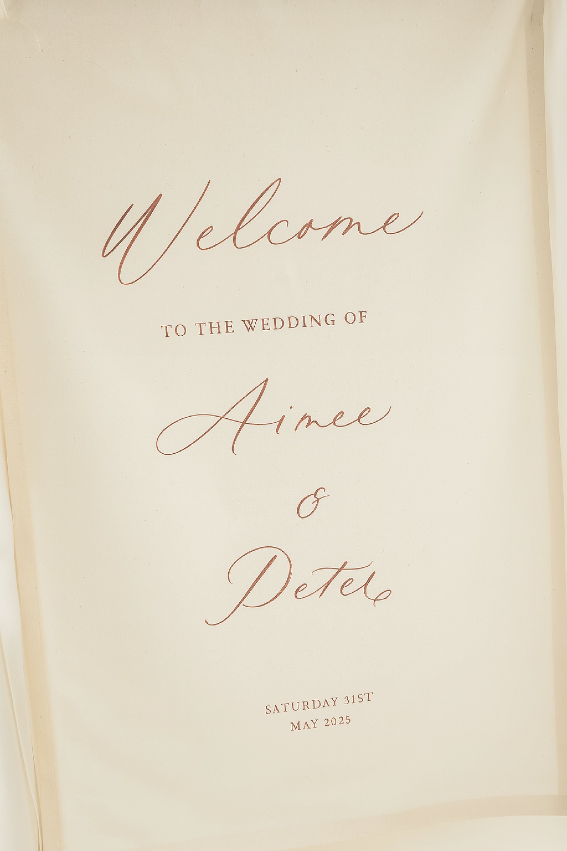Welcome sign for Aimee and Peter's wedding on a beige background