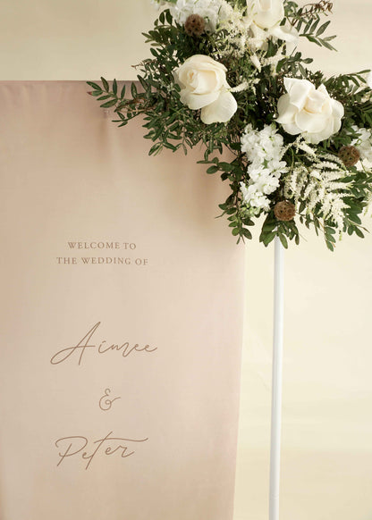 Decorative floral arrangement with a welcome wedding sign on a beige background